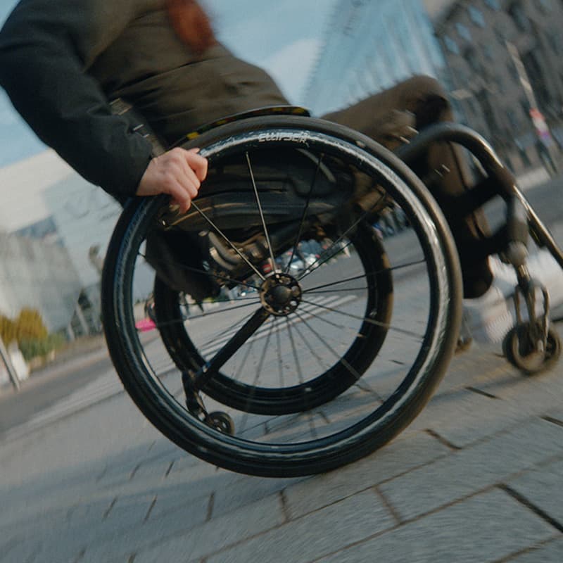 Close-up of a wheelchair moving through the city