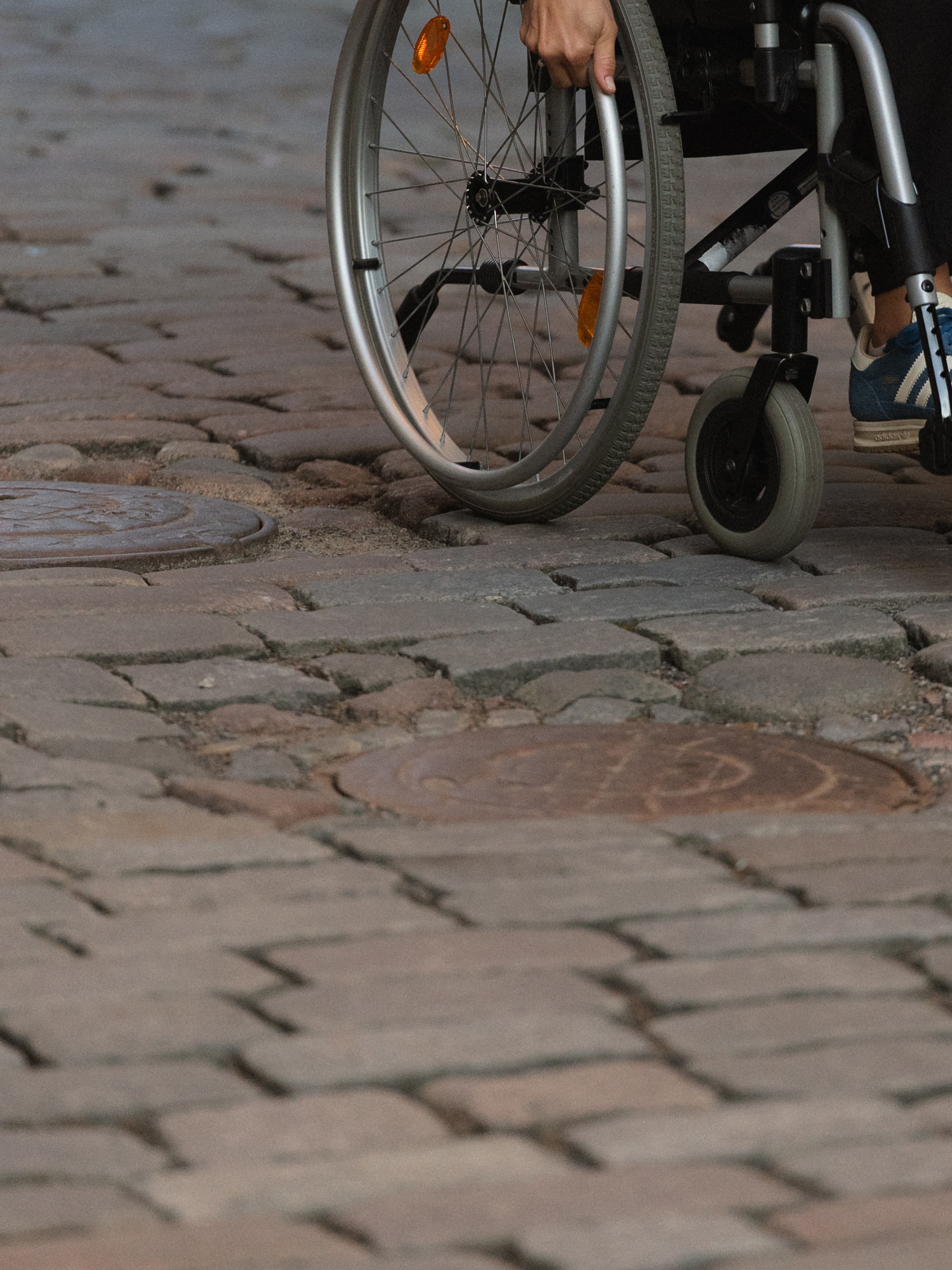 Close-up of wheelchair wheels on cobblestones