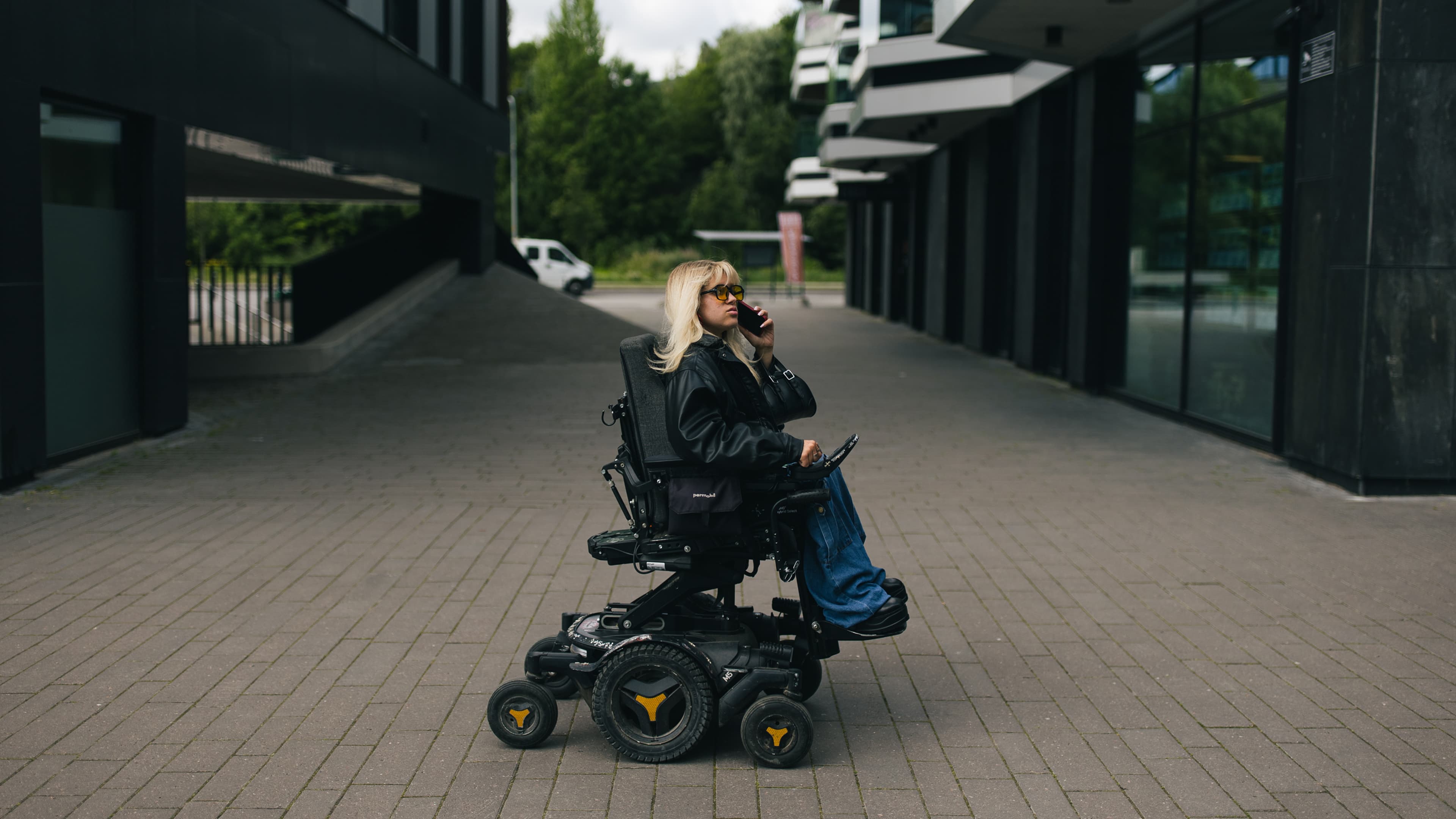 Powerchair user on a phone call in an urban plaza