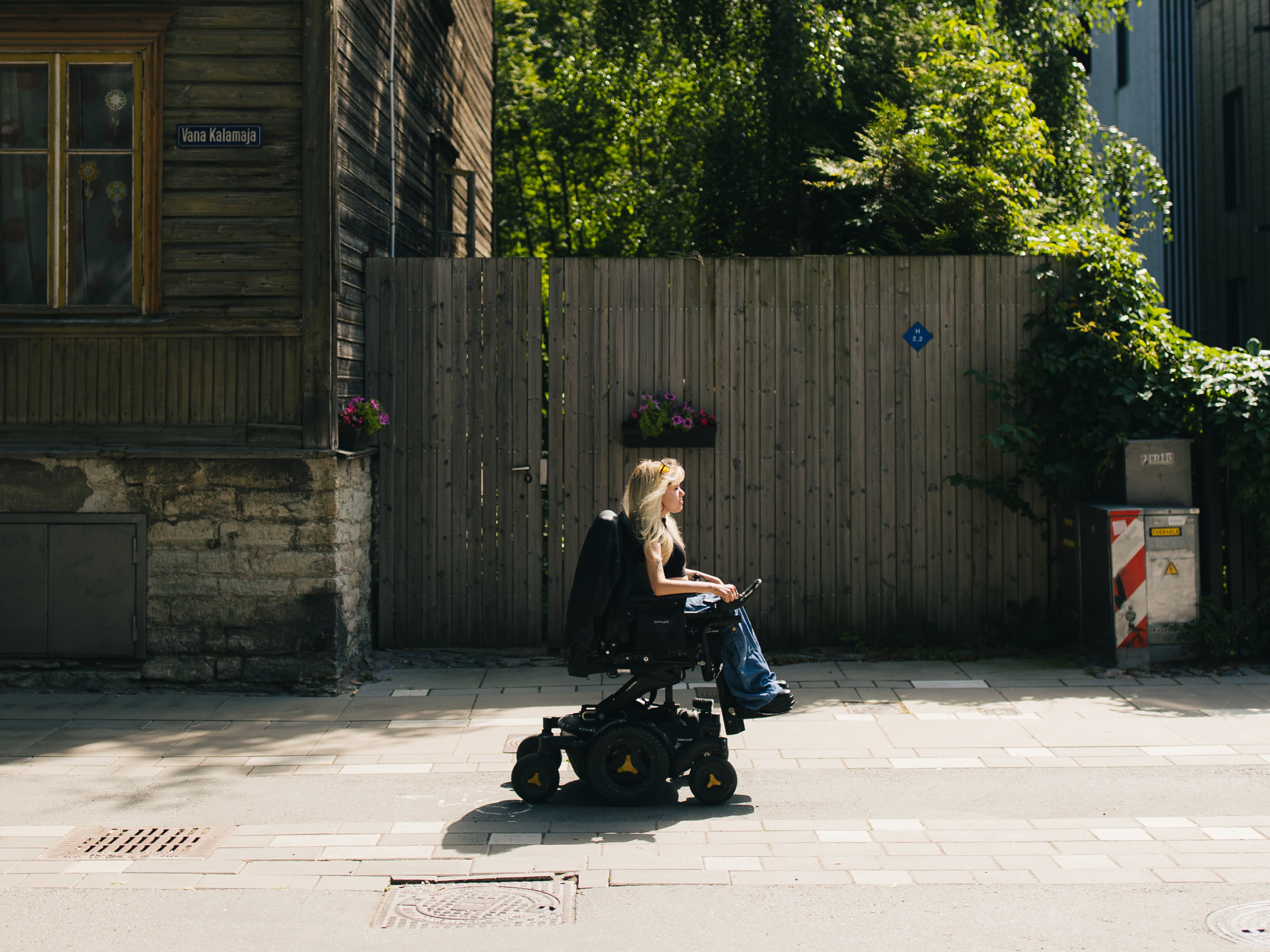 Powerchair user on a sidewalk along Vana-Kalamaja