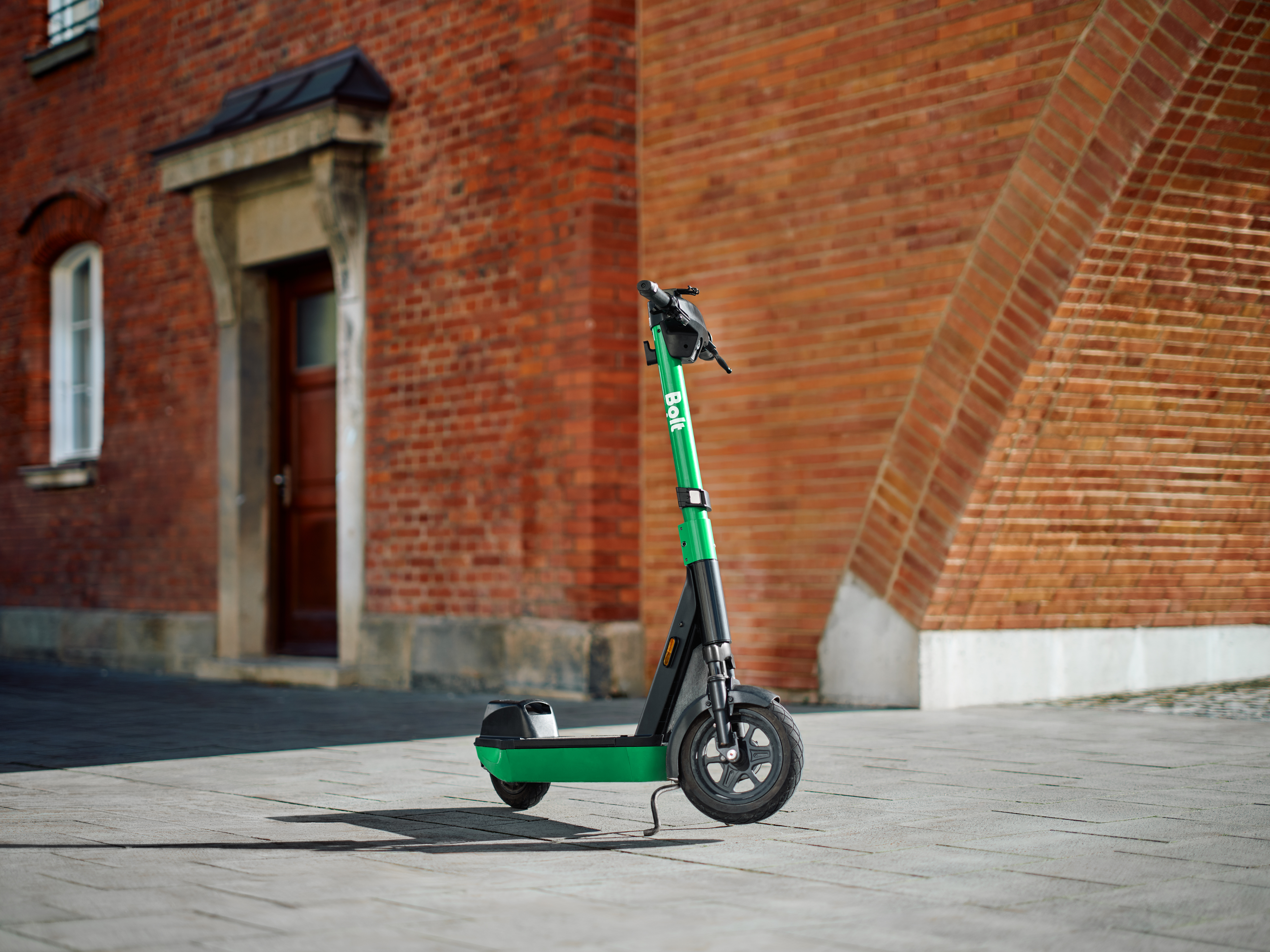 Bolt scooter parked in front of a brick building