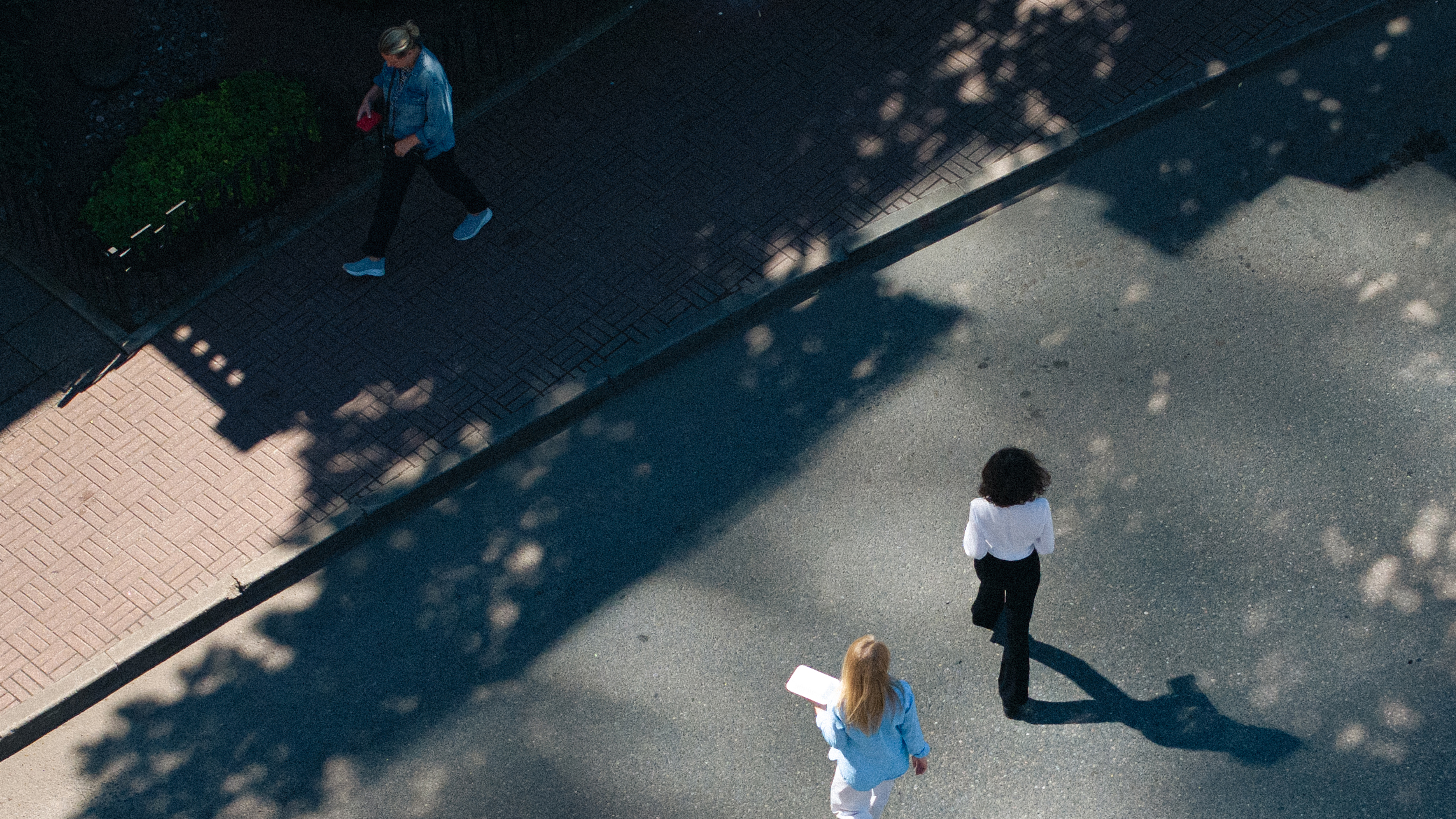 Overhead view of pedestrians on a sidewalk and street
